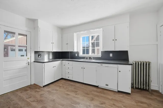 a kitchen with granite countertop white cabinets and sink