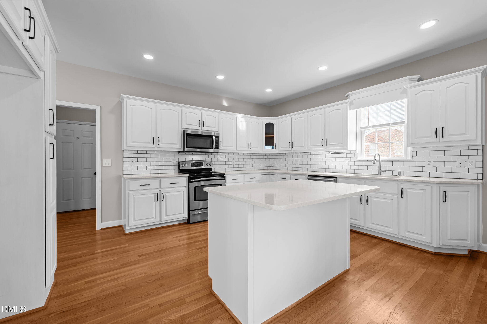 2327 Olde Spring Court Graham, NC 27253 - Photo 17 of 49 a kitchen with stainless steel appliances granite countertop a stove top oven a refrigerator a sink and dishwasher with wooden floor