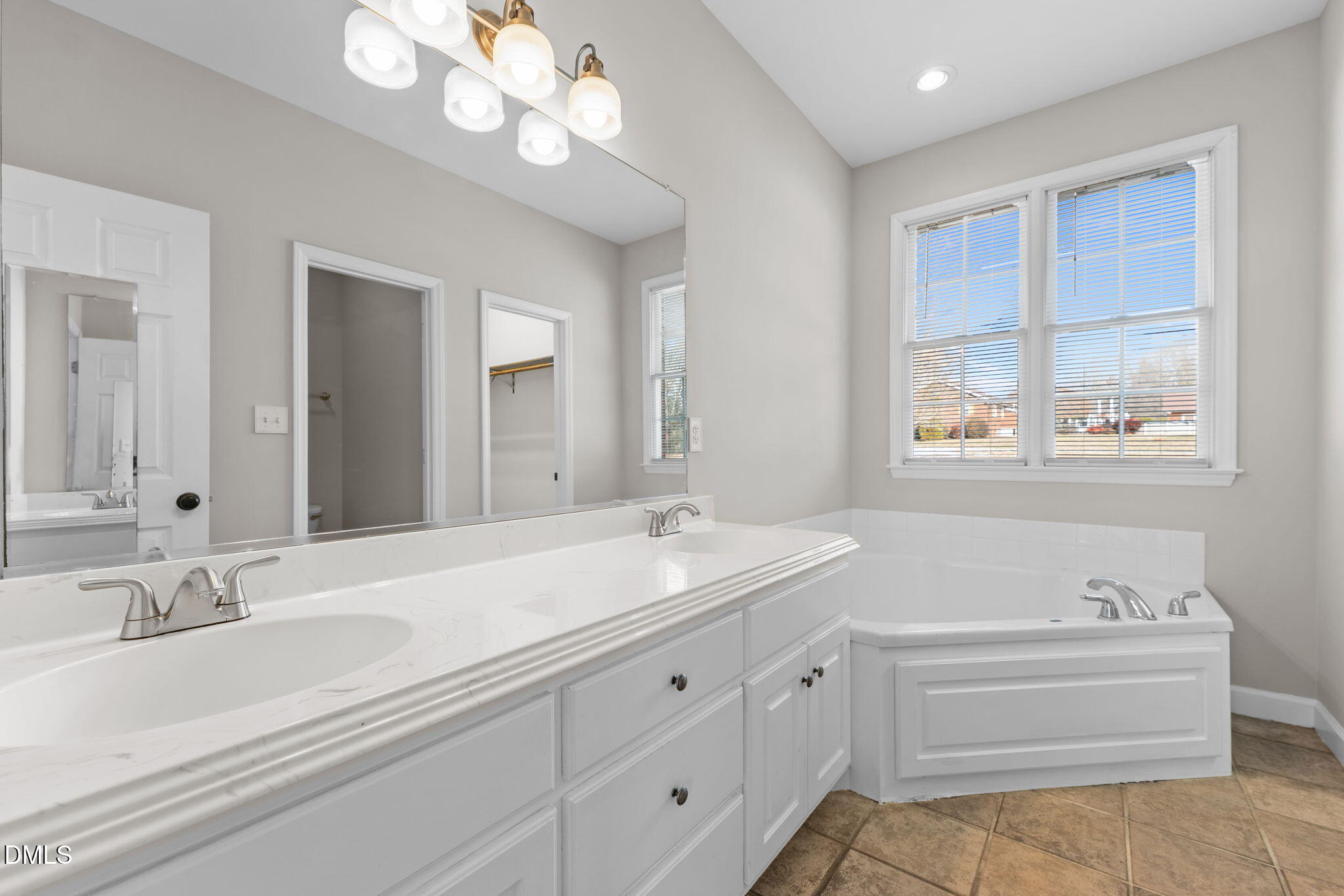 2327 Olde Spring Court Graham, NC 27253 - Photo 27 of 49 a bathroom with a sink a large mirror and a bathtub