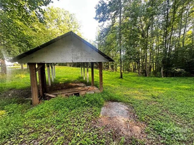 a view of a grassy field with trees in the background