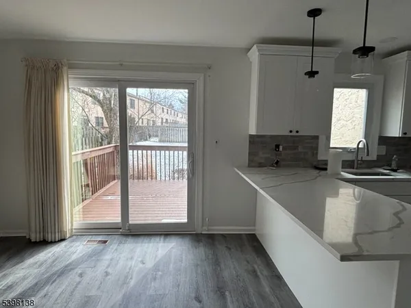 a view of a kitchen with a sink and wooden floor