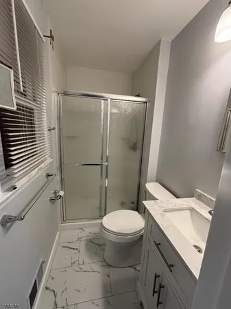 a white toilet sitting next to a bathroom sink and a shower
