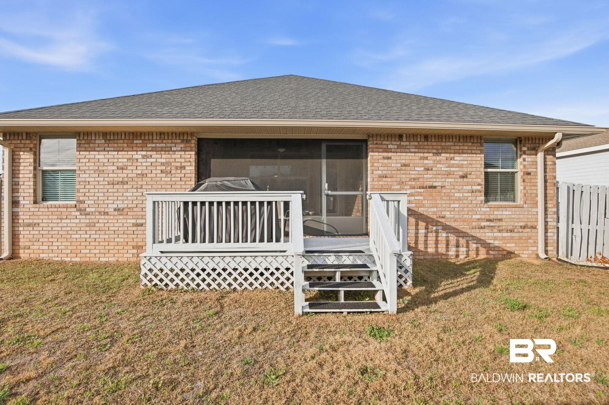 22596 Respite Lane Foley, AL 36535 - Photo 2 of 34 Rear view of house with roof with shingles, a sunroom, brick siding, a lawn, and a deck