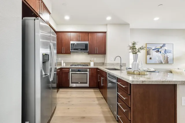 a kitchen with stainless steel appliances granite countertop a sink stove and refrigerator