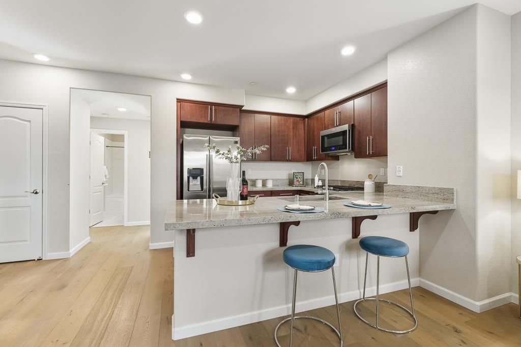 1036 Onofrio Lane, Unit 6 San Jose, CA 95133 - Photo 18 of 50 a kitchen with kitchen island granite countertop a sink and cabinets