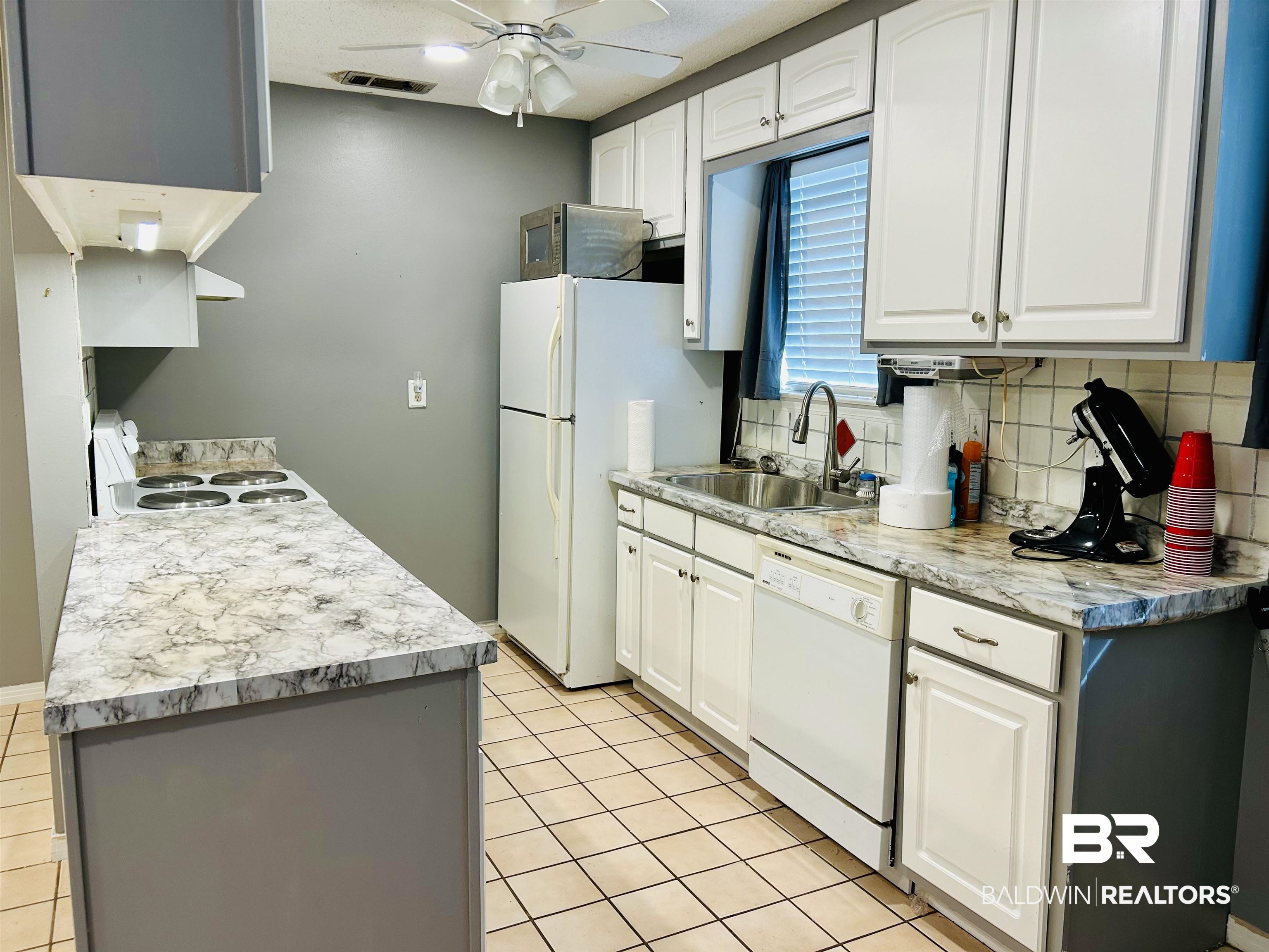 5925 Dixie Lane Mobile, AL 36693 - Photo 16 of 19 Kitchen with white cabinetry, white appliances, sink, and tasteful backsplash