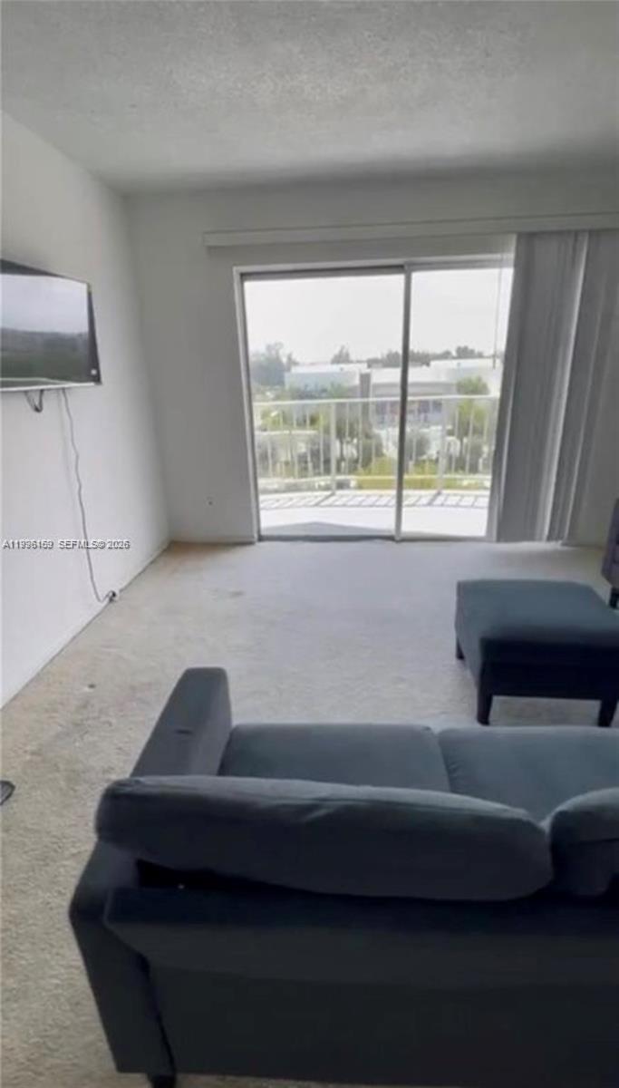 496 Northwest 165th Street, Unit D611 Miami, FL 33169 - Photo 2 of 8 a living room with a couch and a large window