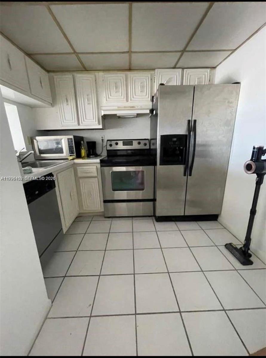 496 Northwest 165th Street, Unit D611 Miami, FL 33169 - Photo 4 of 8 a kitchen with cabinets and steel stainless steel appliances