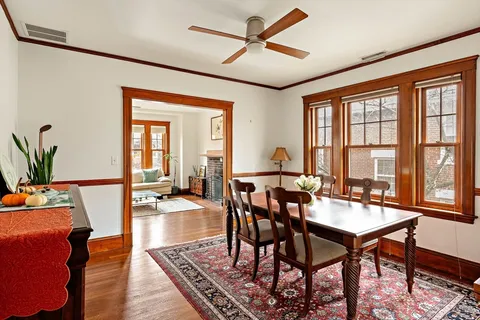 a dining room with furniture a chandelier and wooden floor
