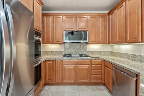 a kitchen with stainless steel appliances granite countertop a refrigerator and a sink