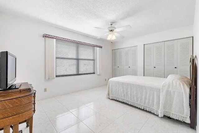 a bedroom with a bed and a ceiling fan