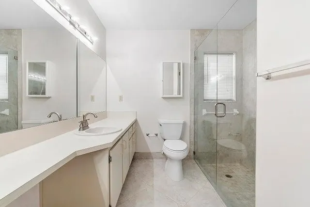 a bathroom with a double vanity sink toilet and shower