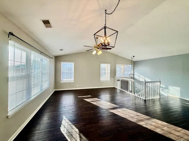 a view of dining room with wooden floor and chandelier