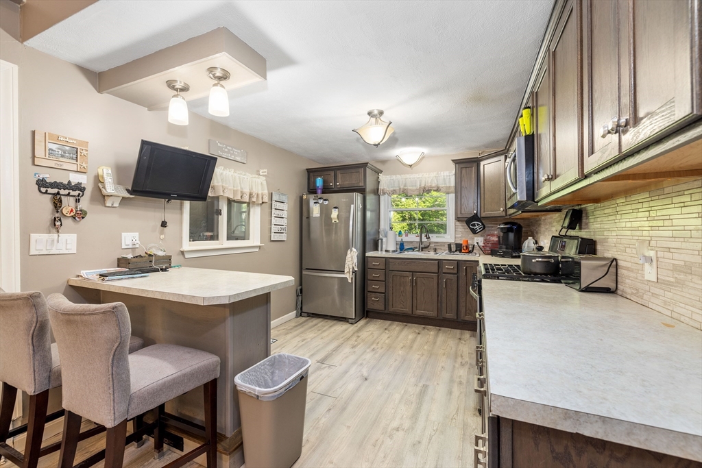 8 Hurlburt Road Billerica, MA 01821 - Photo 3 of 9 a kitchen with a table chairs refrigerator and a sink
