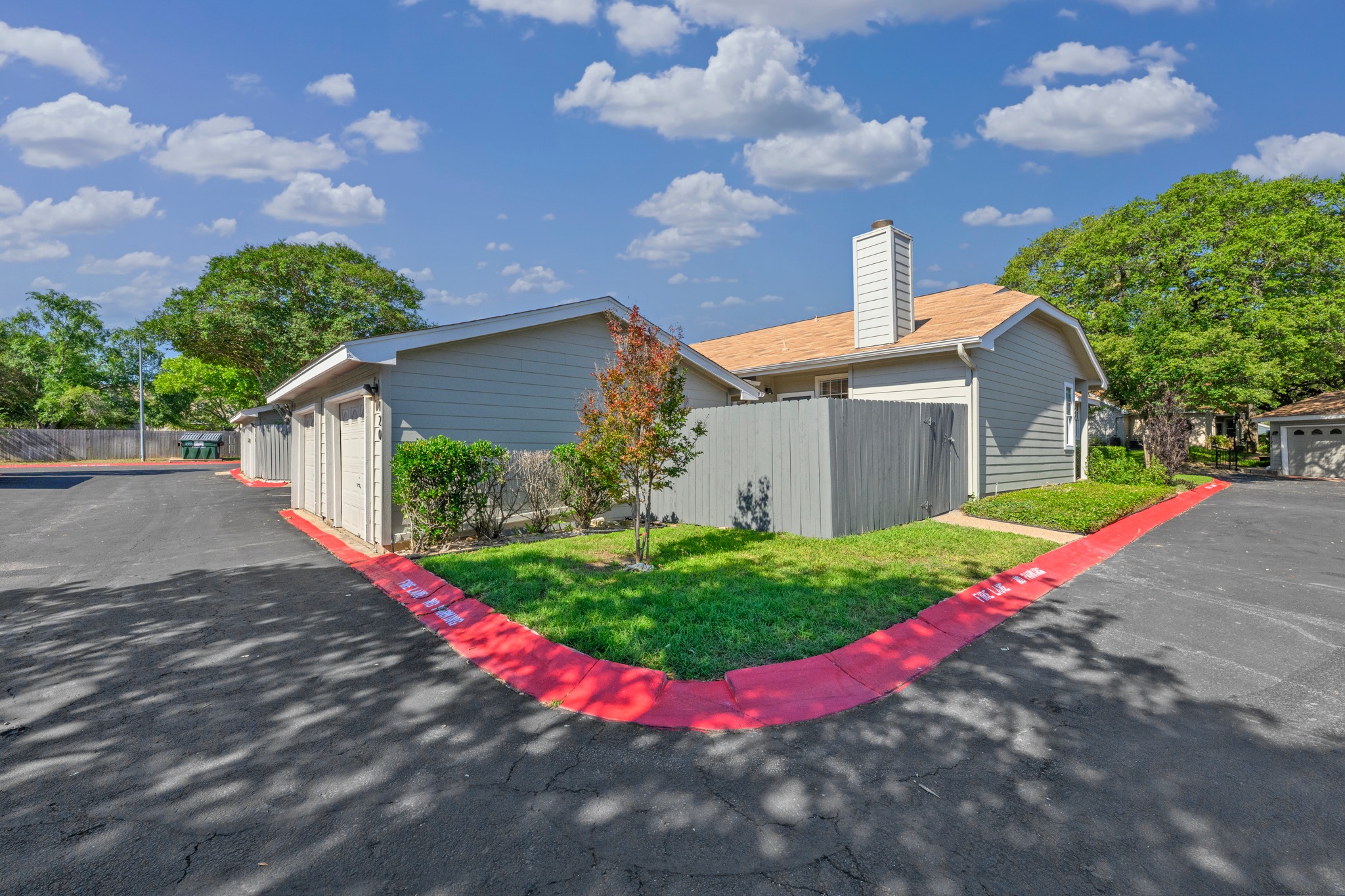 6501 Brush Country Road, Unit 120 Austin, TX 78749 - Photo 24 of 26 Exterior featuring light gray siding, a tan shingle roof, and a prominent chimney