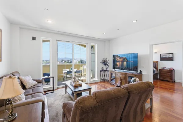a living room with furniture a flat screen tv and a large window