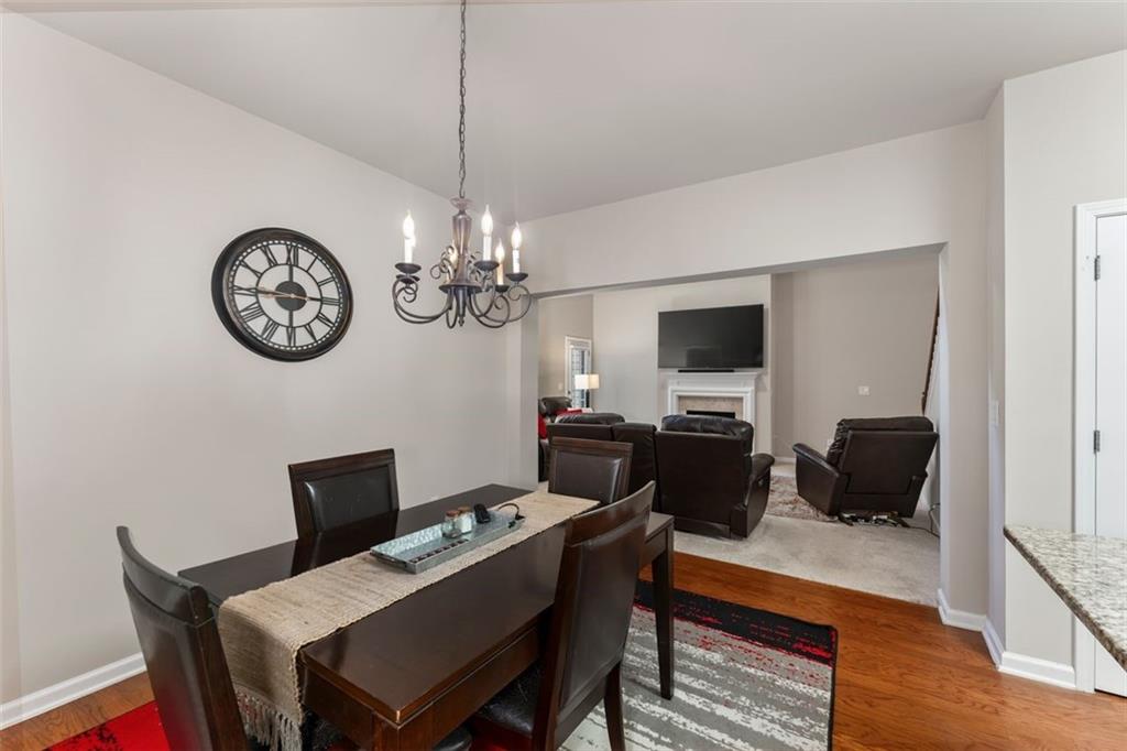 113 Tyson Woods Road Acworth, GA 30102 - Photo 18 of 37 a view of a dining room with furniture a chandelier and wooden floor