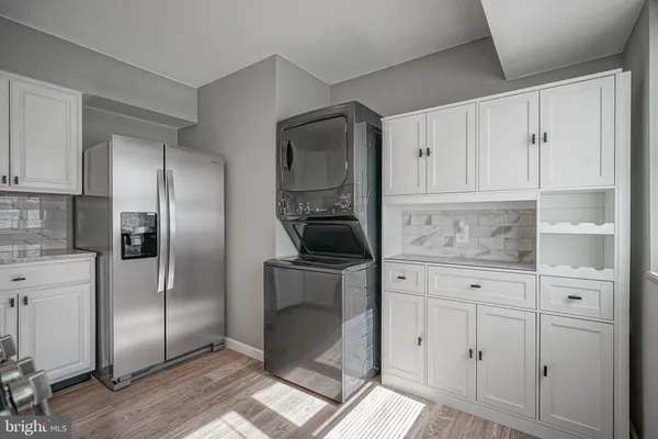 a kitchen with white cabinets and refrigerator