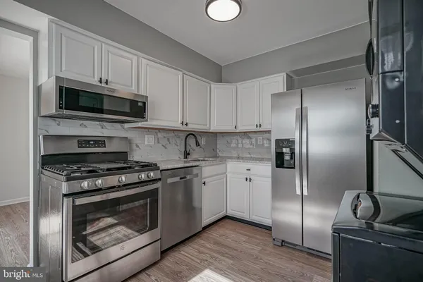 a kitchen with stainless steel appliances granite countertop a stove a refrigerator and a microwave