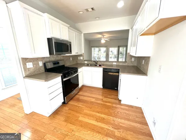 a kitchen with a sink stove and microwave