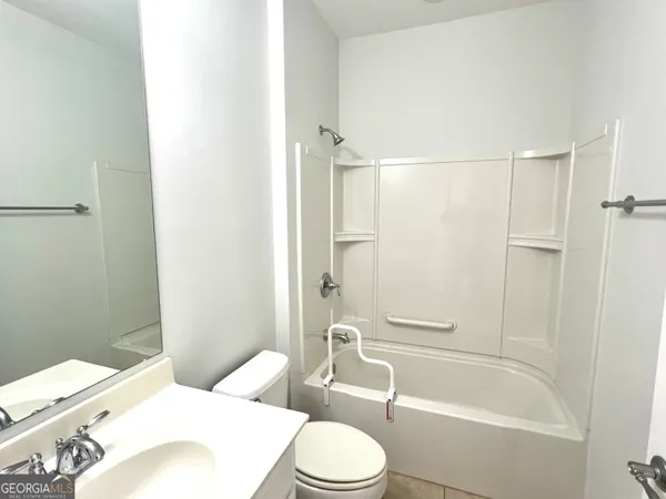a white toilet and tub sitting next to a bathroom sink