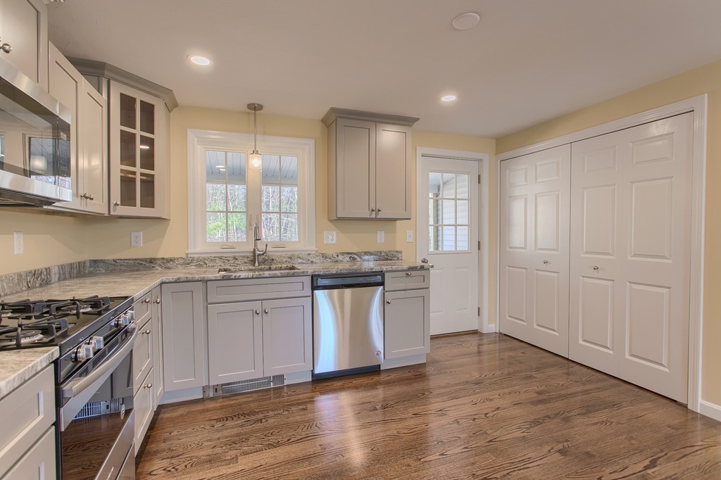 8 Shawnee Road, Unit B Pepperell, MA 01463 - Photo 3 of 18 a kitchen with granite countertop a stove top oven sink and cabinets