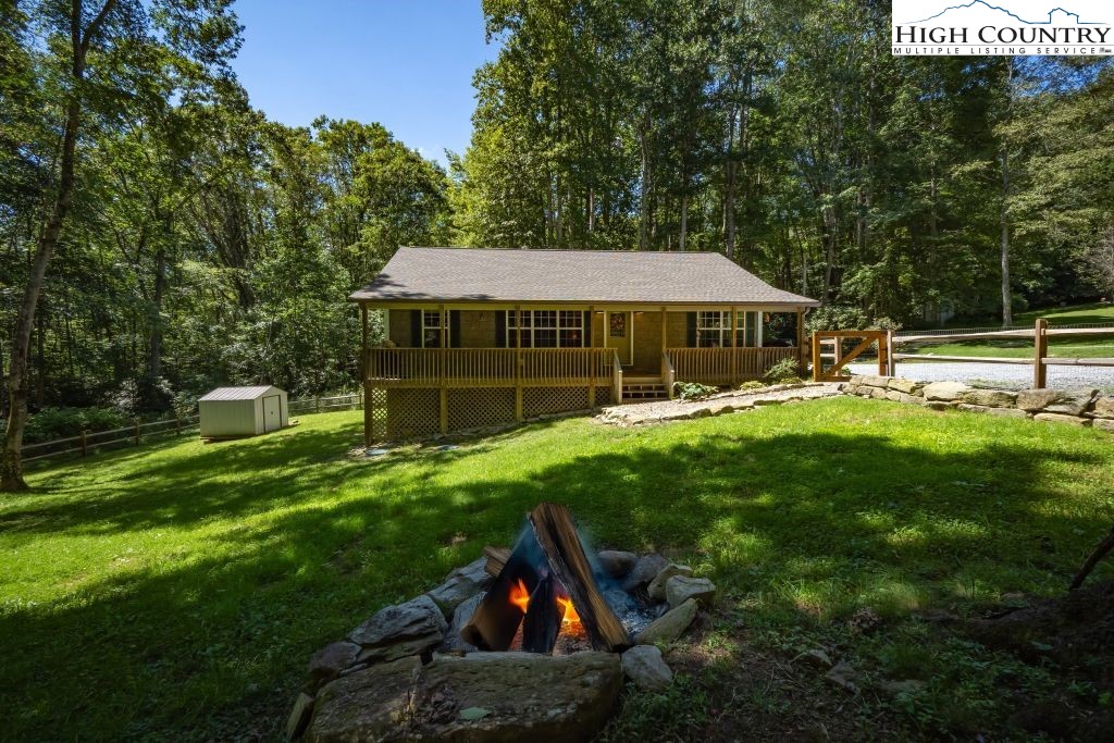 61 Snowbird Lane Linville, NC 28657 - Photo 19 of 19 a view of a house with a backyard and a patio