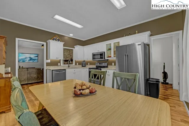 a kitchen with a refrigerator a stove microwave oven with white cabinets and wooden floor