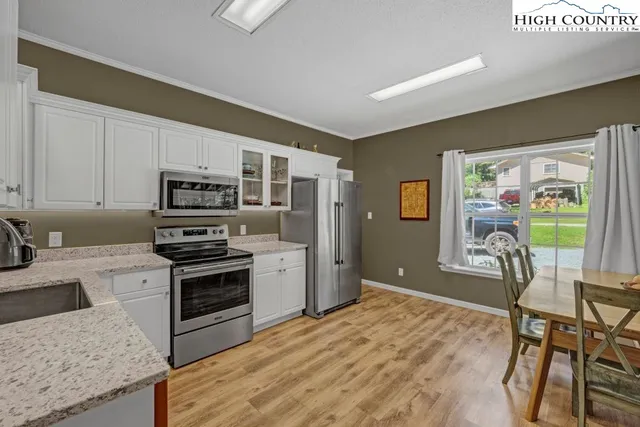 a kitchen with stainless steel appliances granite countertop a stove top oven a sink dishwasher and a refrigerator