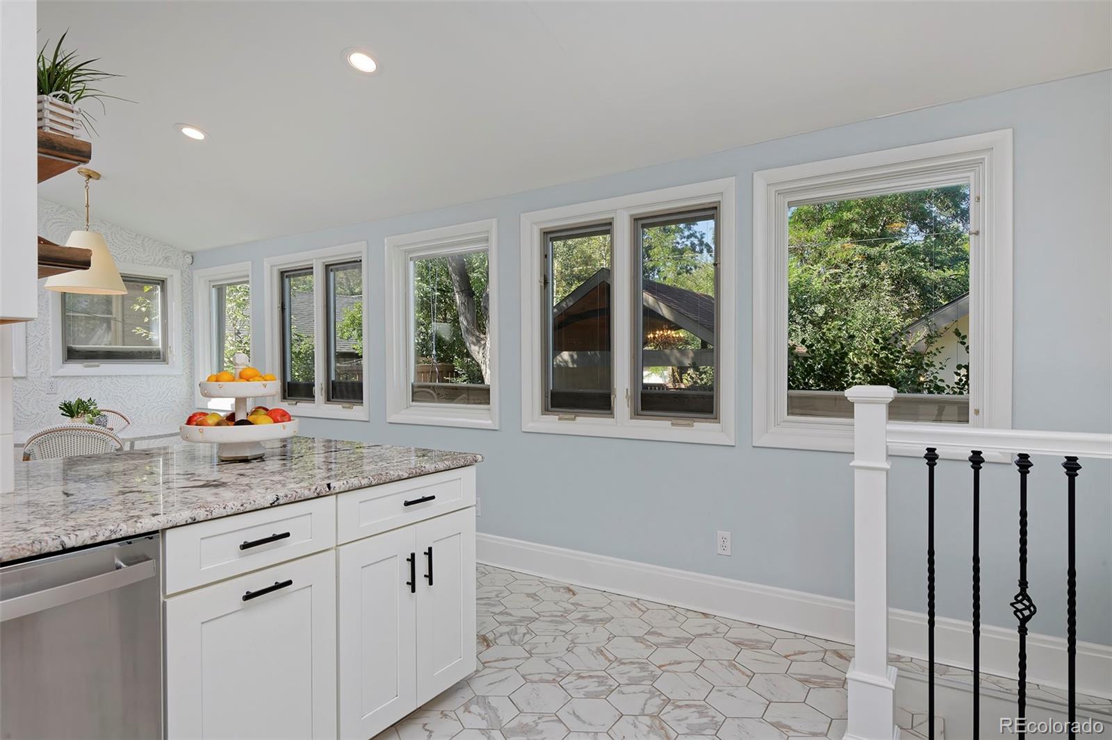 2591 Ash Street Denver, CO 80207 - Photo 16 of 48 a kitchen with stainless steel appliances granite countertop a stove a sink and a granite counter tops with white cabinets