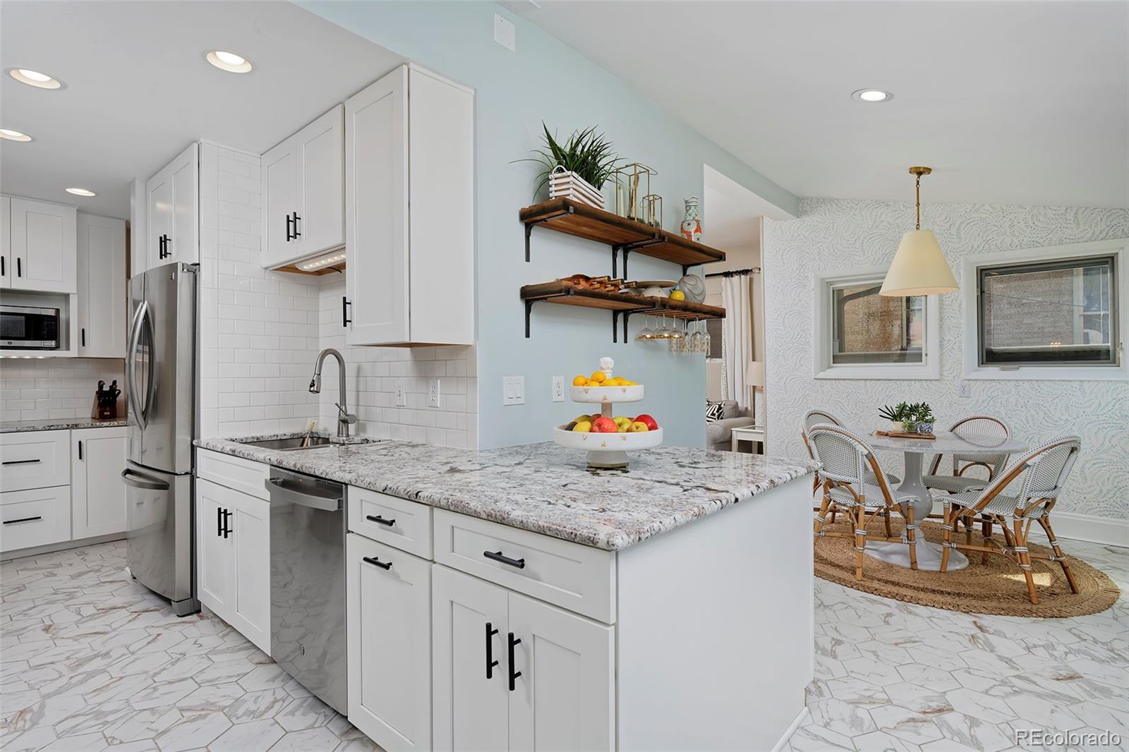 2591 Ash Street Denver, CO 80207 - Photo 17 of 48 a kitchen with stainless steel appliances granite countertop a sink stove and refrigerator