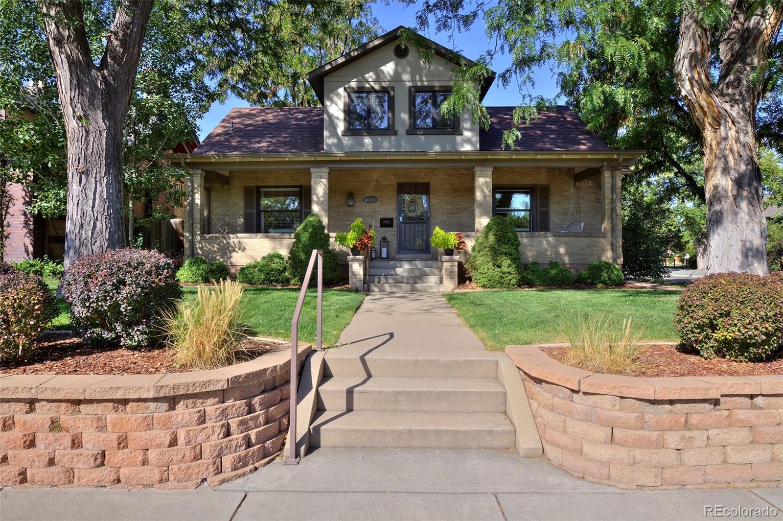 2591 Ash Street Denver, CO 80207 - Photo 2 of 48 a front view of a house with garden and porch