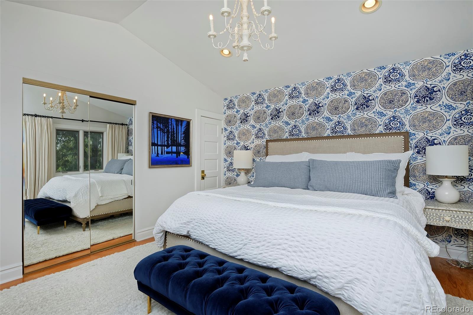 2591 Ash Street Denver, CO 80207 - Photo 26 of 48 a bedroom with a large bed and a chandelier