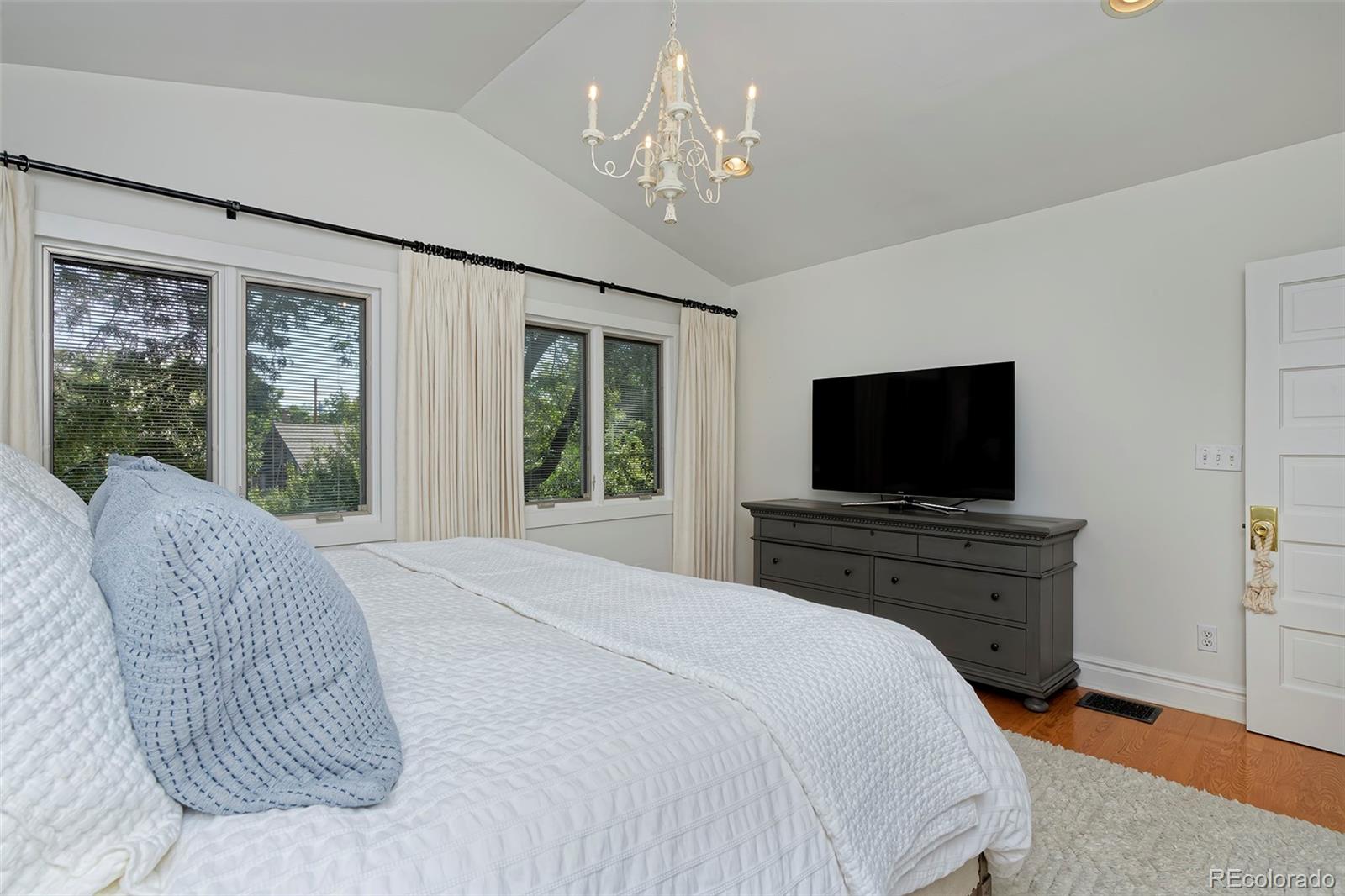 2591 Ash Street Denver, CO 80207 - Photo 27 of 48 a bedroom with a bed and a flat screen tv