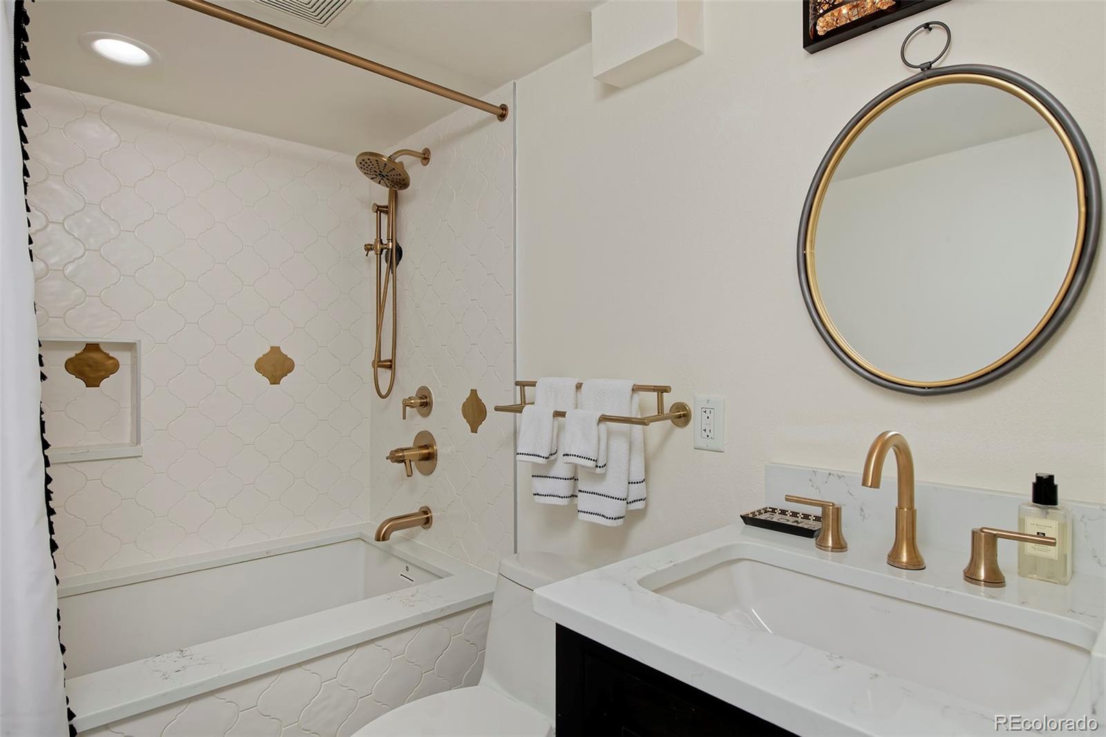 2591 Ash Street Denver, CO 80207 - Photo 38 of 48 a bathroom with a sink a toilet and a mirror