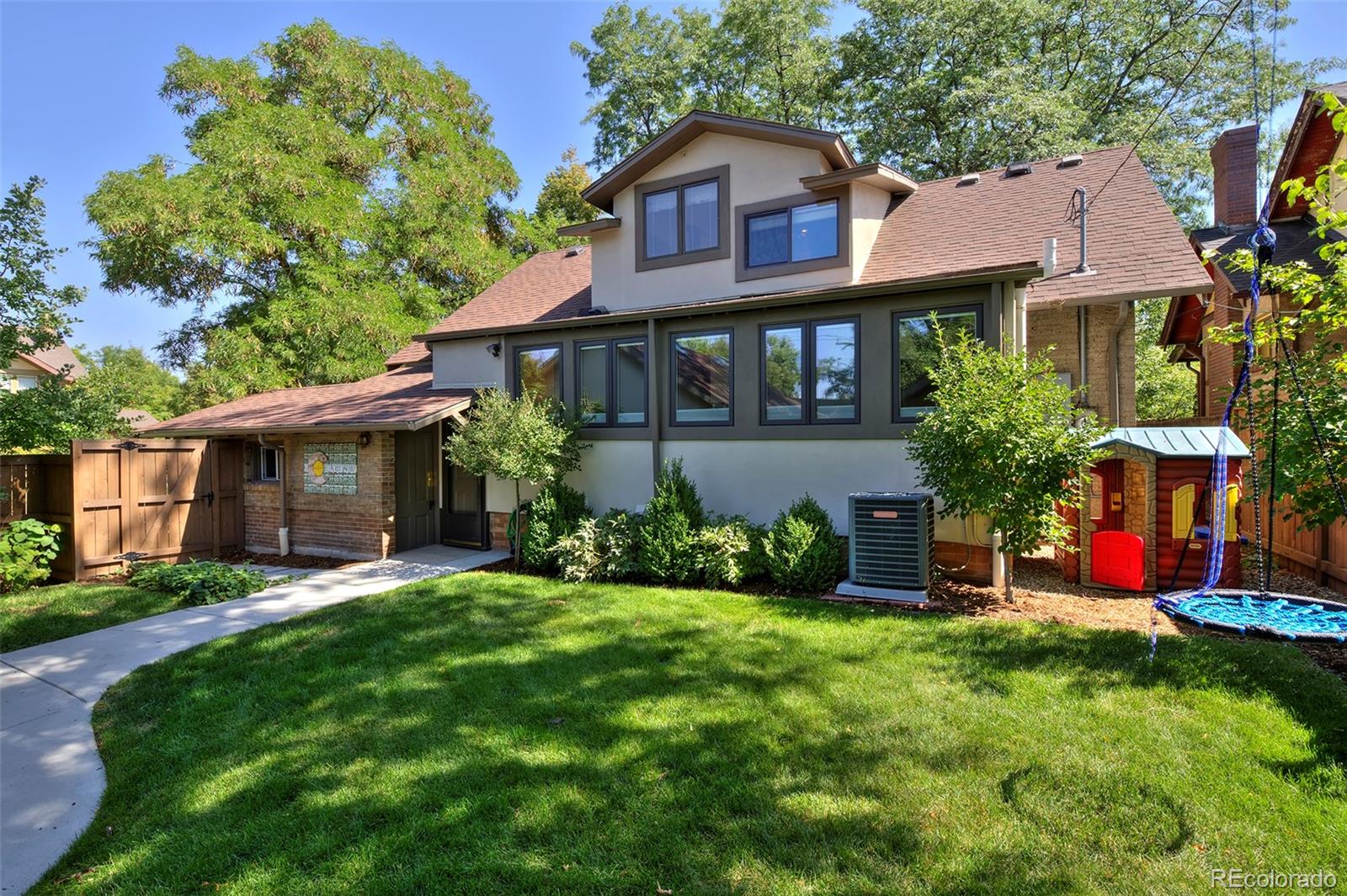 2591 Ash Street Denver, CO 80207 - Photo 47 of 48 a front view of a house with a yard and trees