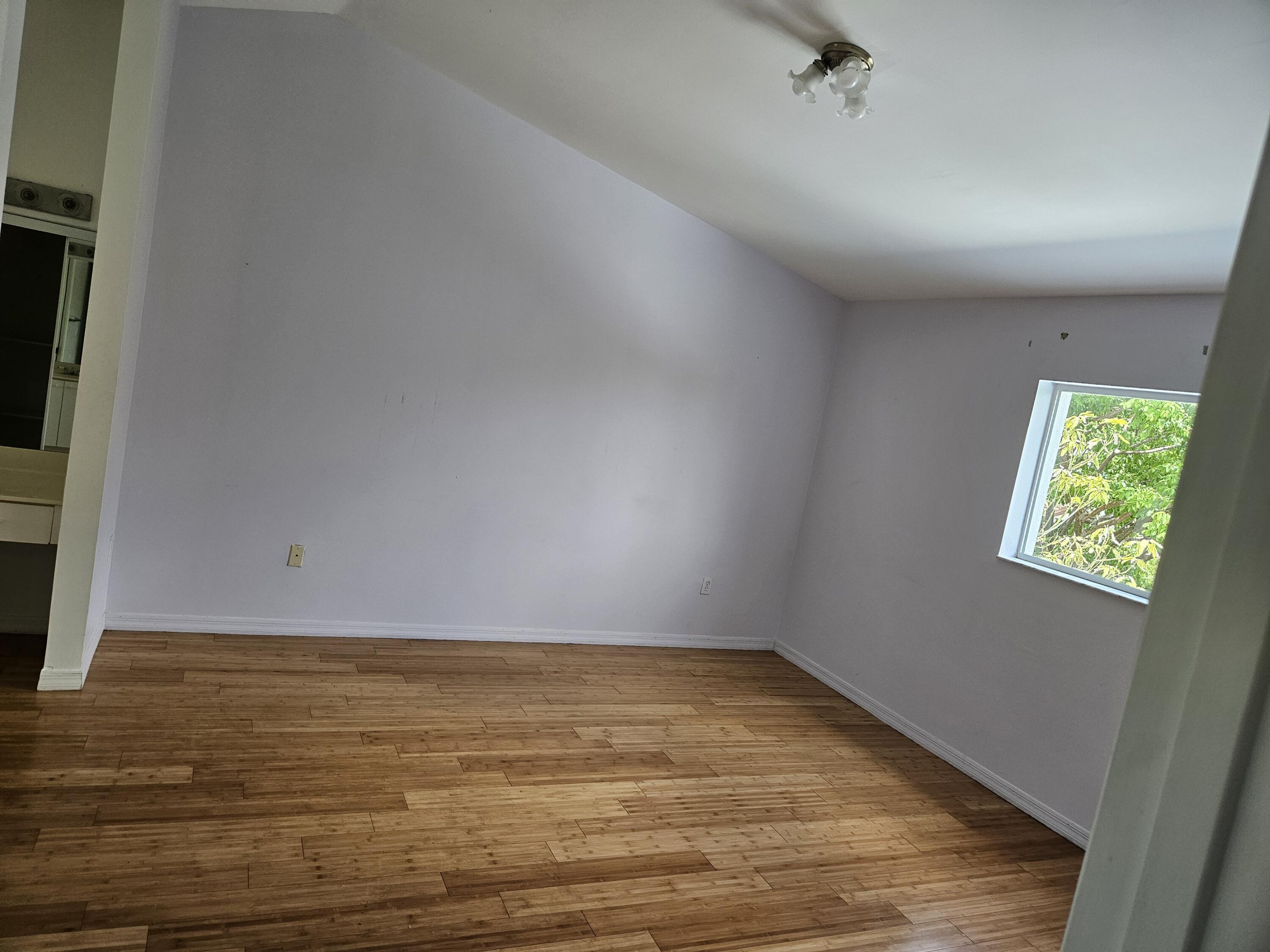 21109 Northeast 3rd Court Miami, FL 33179 - Photo 12 of 30 a view of an empty room with wooden floor and a window