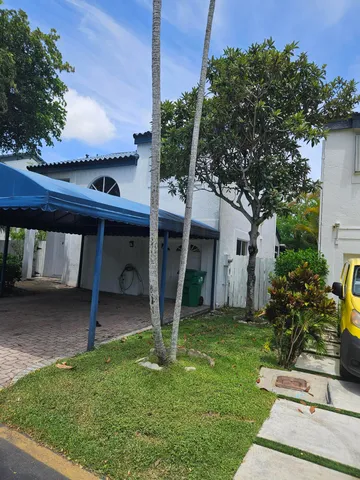 a view of a house with backyard and a tree
