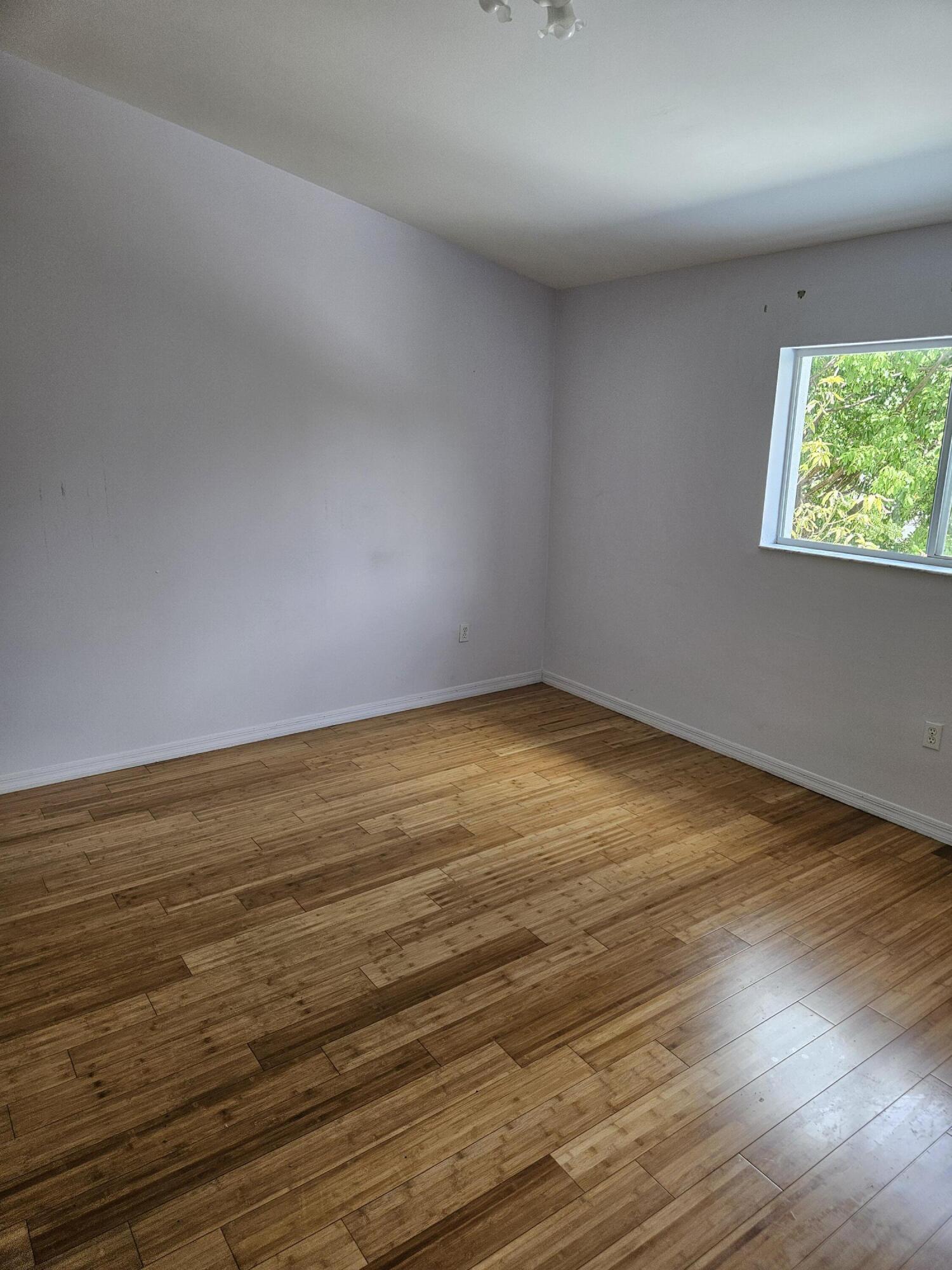 21109 Northeast 3rd Court Miami, FL 33179 - Photo 23 of 30 a view of an empty room with wooden floor and a window