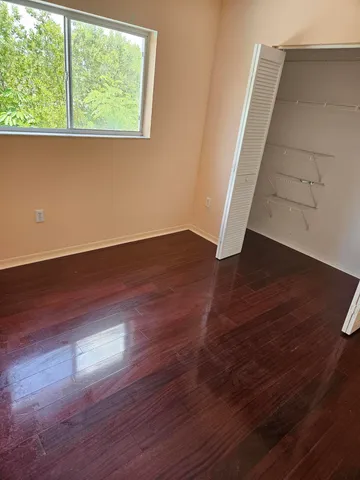 an empty room with wooden floor and closet