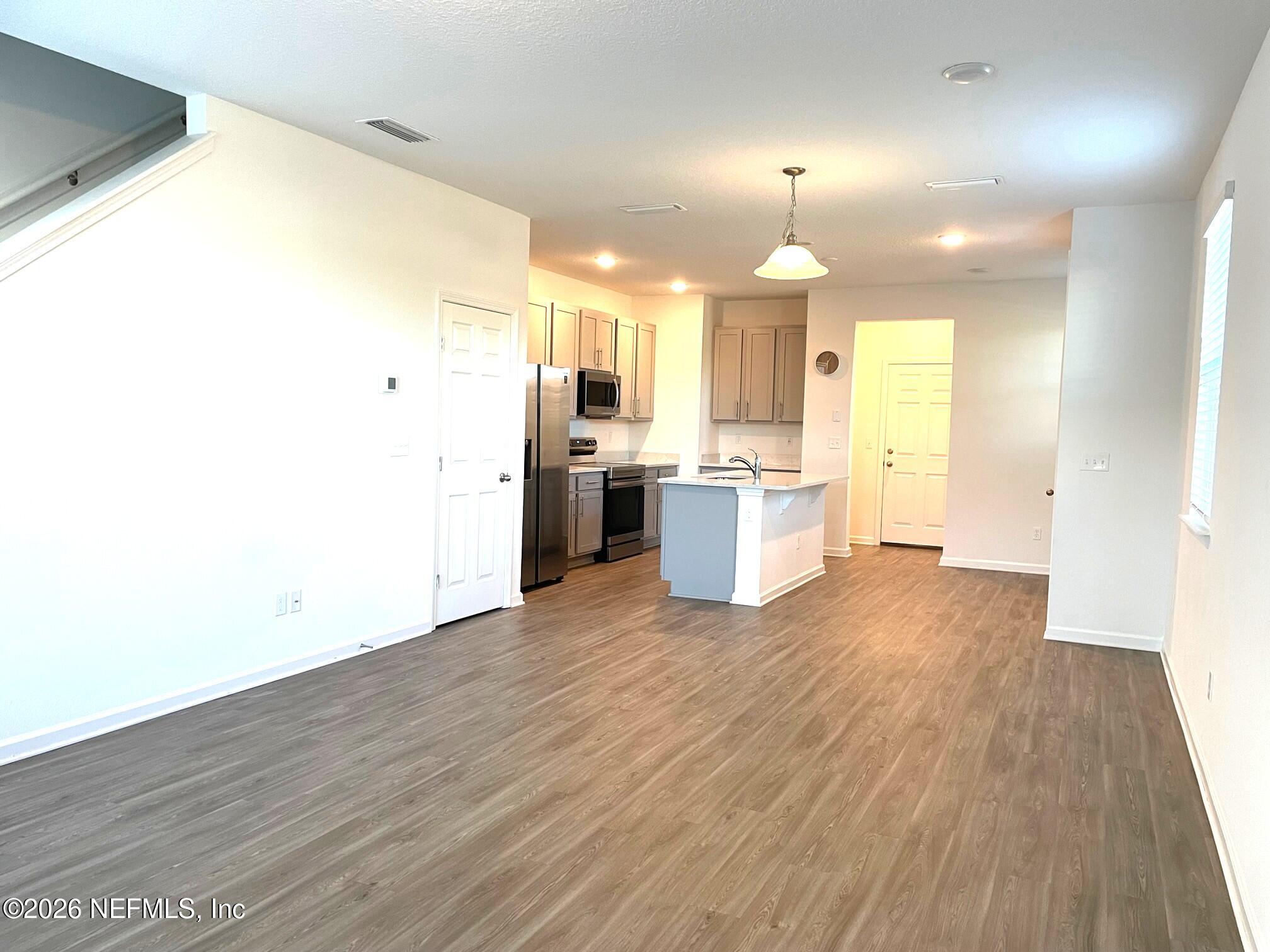 106 Ridge Lake Rd Street St. Augustine, FL 32086 - Photo 11 of 31 a large kitchen with a wooden floor and stainless steel appliances