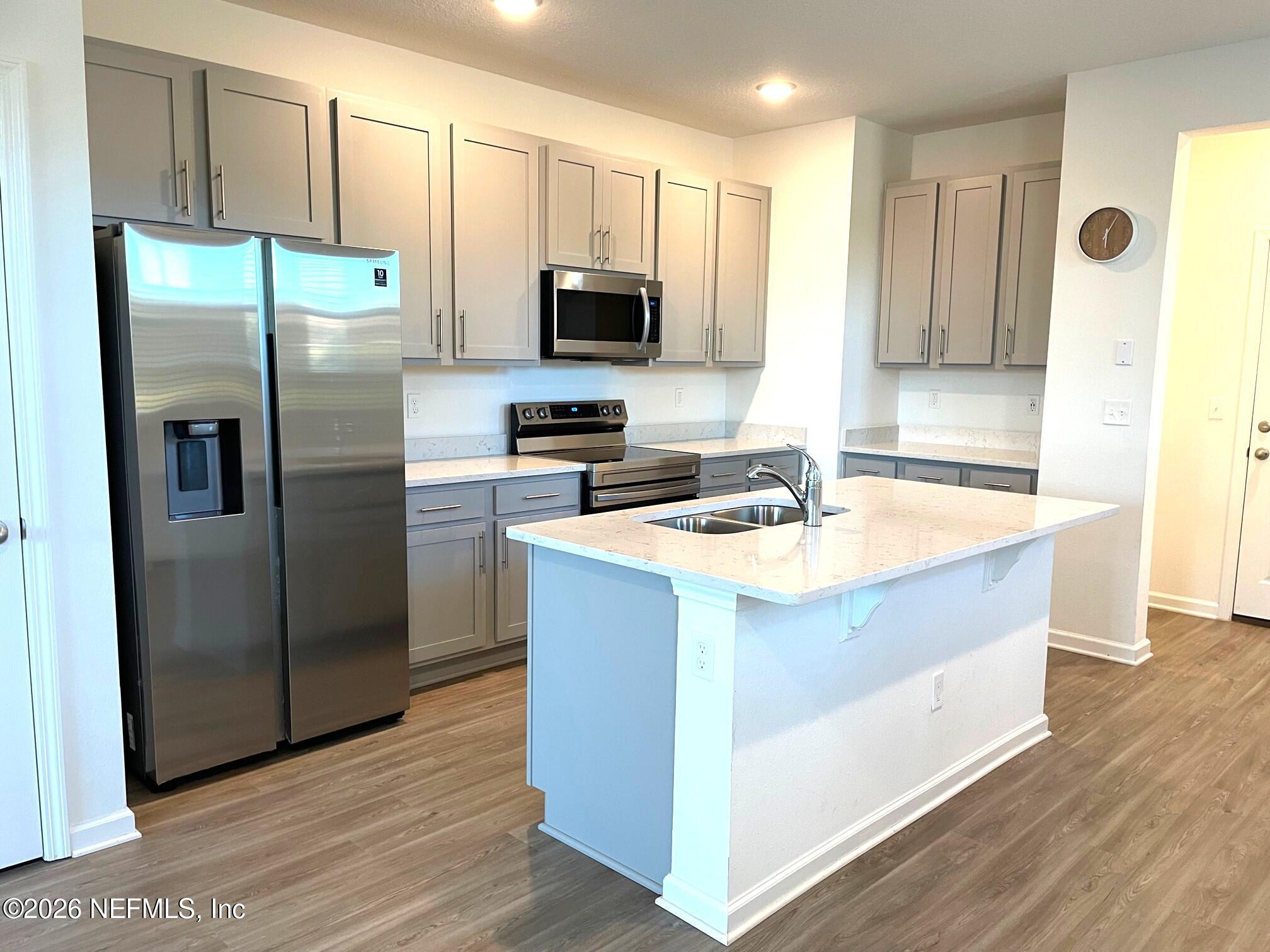 106 Ridge Lake Rd Street St. Augustine, FL 32086 - Photo 4 of 31 a kitchen with stainless steel appliances a refrigerator a sink a stove a microwave and wooden floor
