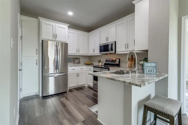 a kitchen with stainless steel appliances a refrigerator stove microwave and cabinets
