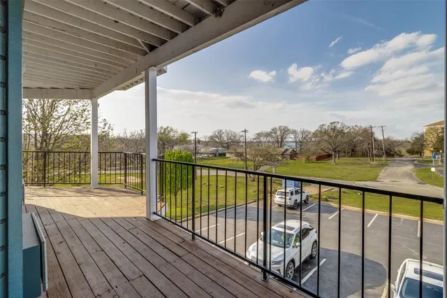 a view of roof deck with wooden floor and fence