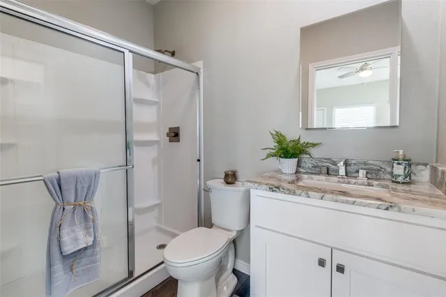a bathroom with a granite countertop sink toilet and shower