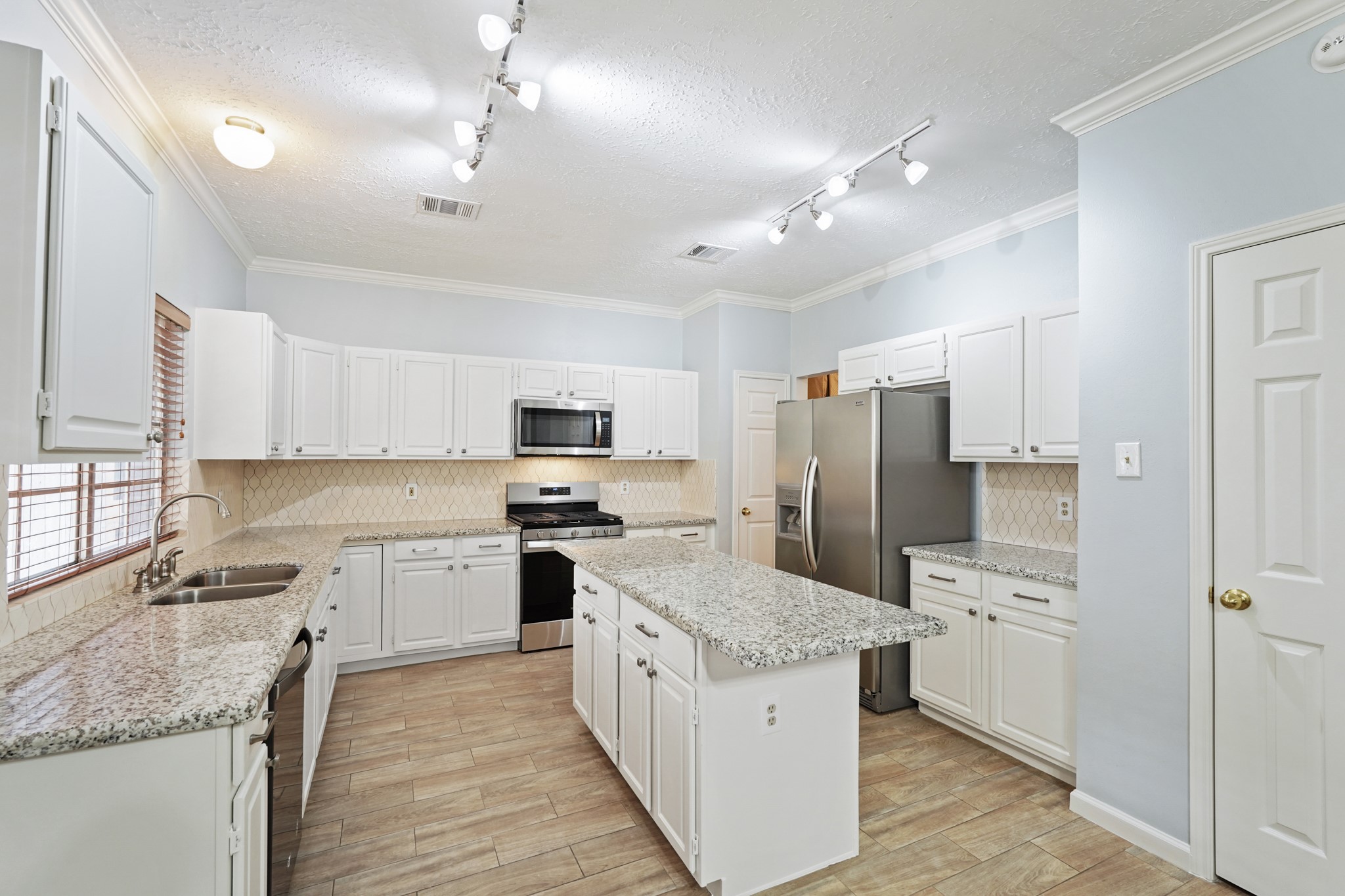 16215 Wemyss Bay Road Houston, TX 77095 - Photo 3 of 44 a kitchen with kitchen island granite countertop a sink refrigerator and microwave
