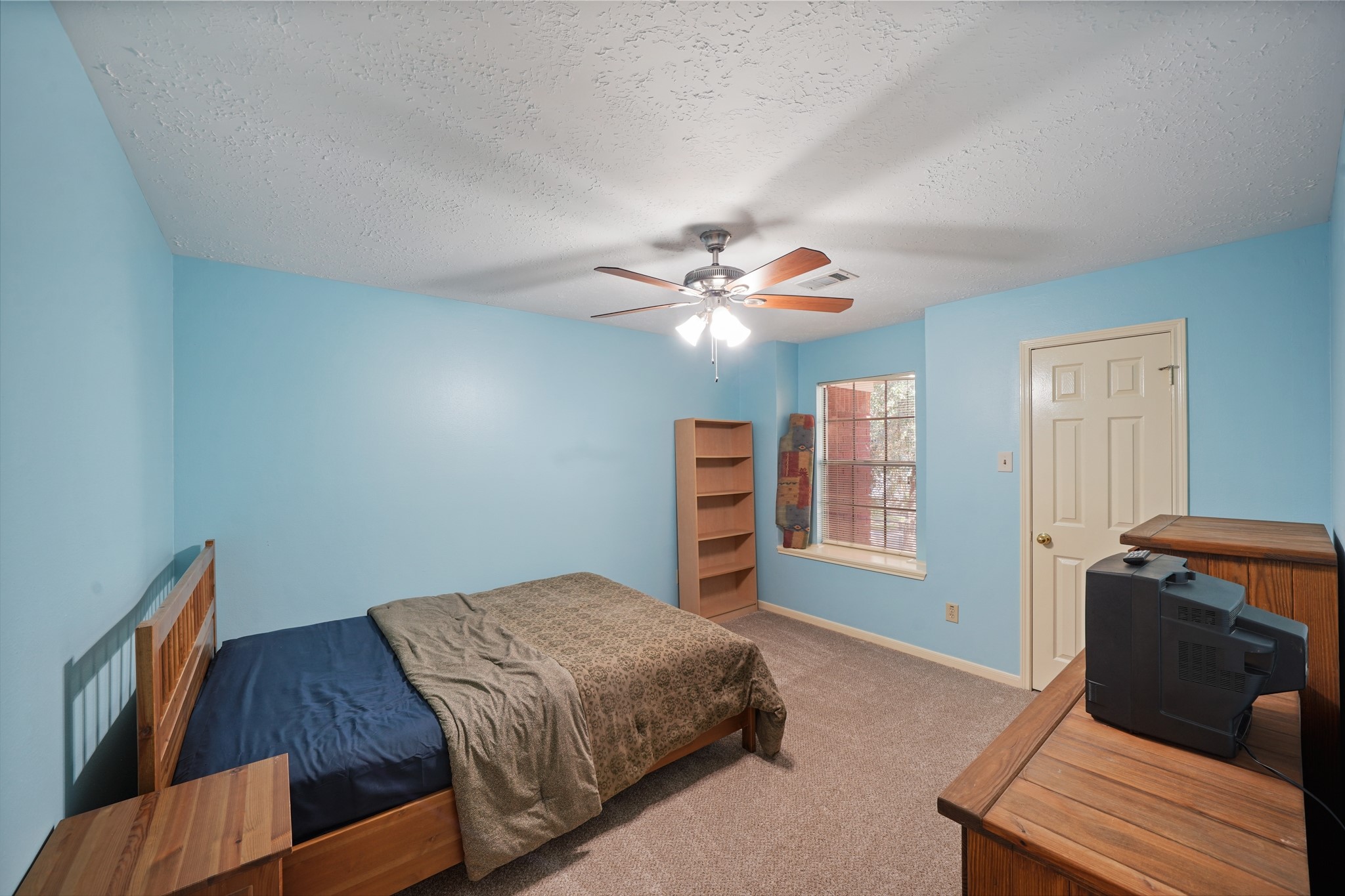 16215 Wemyss Bay Road Houston, TX 77095 - Photo 34 of 44 a bedroom with a bed and a chandelier