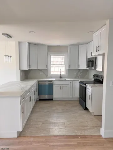 a large kitchen with a white cabinets and white stainless steel appliances