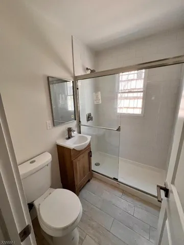 a bathroom with a toilet a sink a mirror and a shower