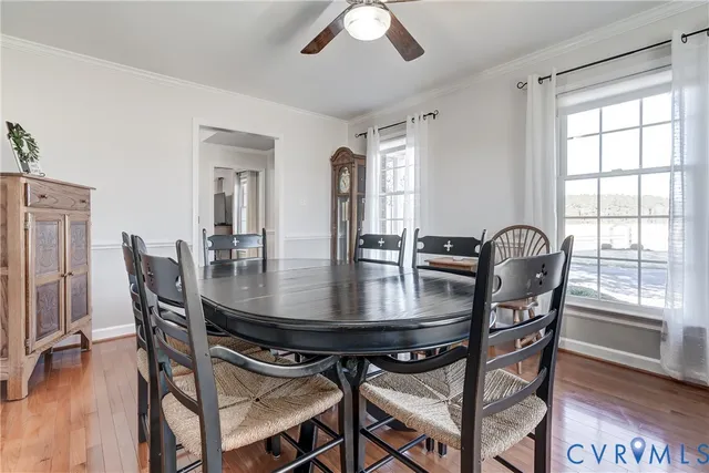 a kitchen with granite countertop a stove a sink a dining table and chairs with wooden floor